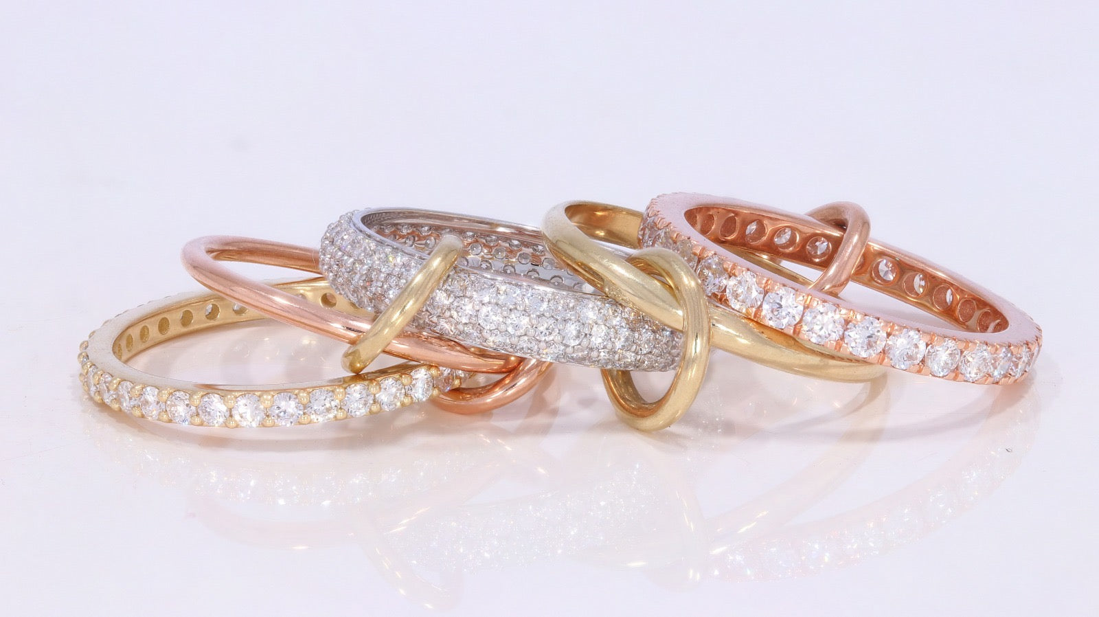 Locked and stocked ring shown laying down five gold bands and rings holding it together