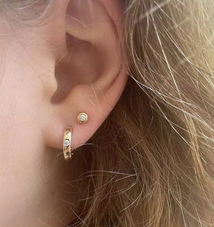 Model wearing Forever Yours diamond huggie hoop earrings in 14k gold with subtle sparkle