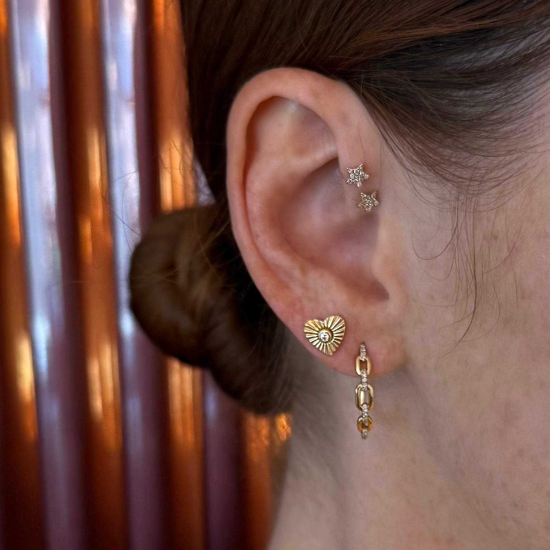 Close-up of Harmless Flirt pavé hoop earrings in curated ear stack on model
