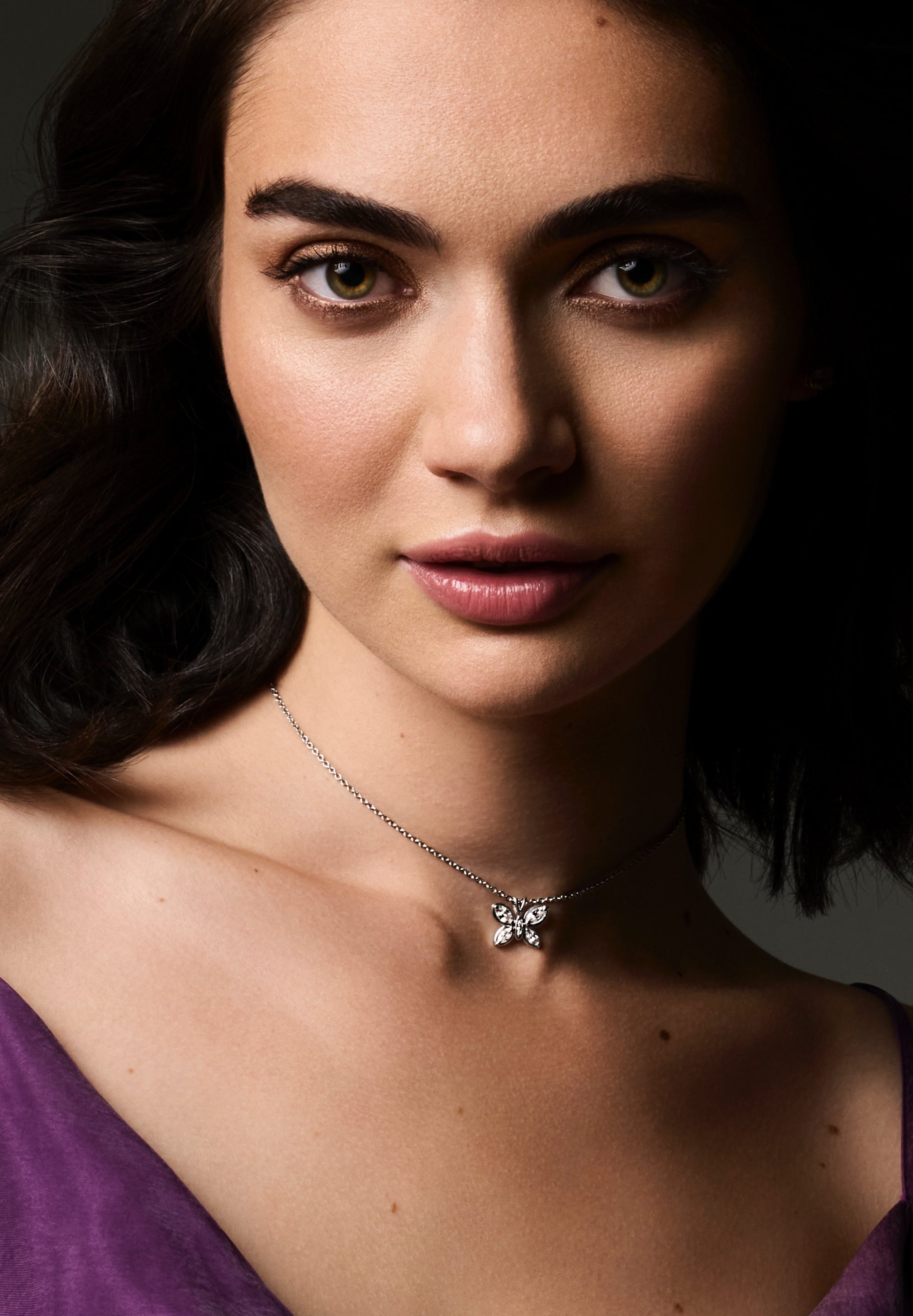 Editorial image of model wearing Jasmine's Butterfly Pendant in white gold with marquise and round diamonds