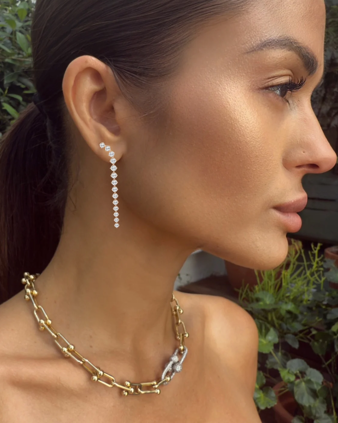 Model wearing Lyrical Descent diamond drop earrings in rose gold with romantic flow