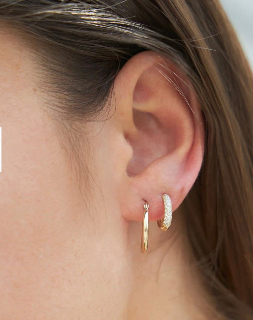 Model wearing Mini Snugglers diamond pavé huggie hoop earrings in yellow gold for a comfortable sparkle
