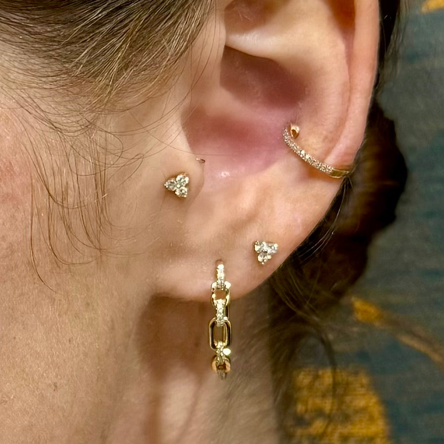 Dainty trio diamond stud earrings on model for everyday wear or second piercing style