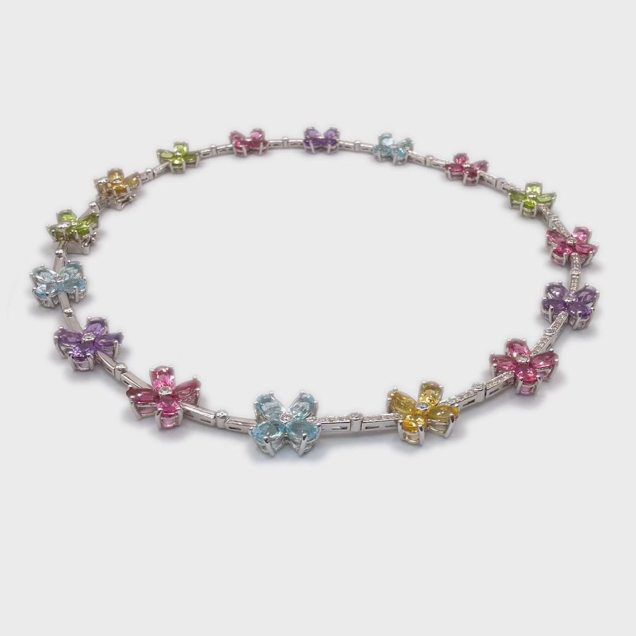 360-degree video of Choker de Fleur 18k gold floral choker necklace with colorful gemstones and diamond accents.