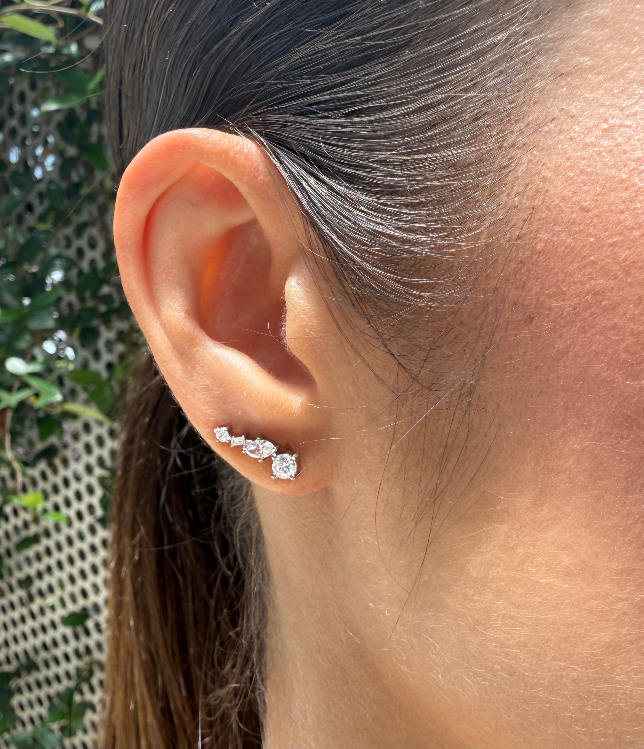 Close-up editorial of Social Climbers ear climber in white gold on ear, showcasing curve-following design