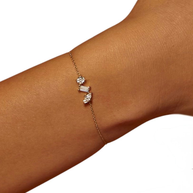 Model wearing The Wish Chain Diamond Bracelet showcasing delicate 14k gold chain and trio of diamond shapes on wrist
