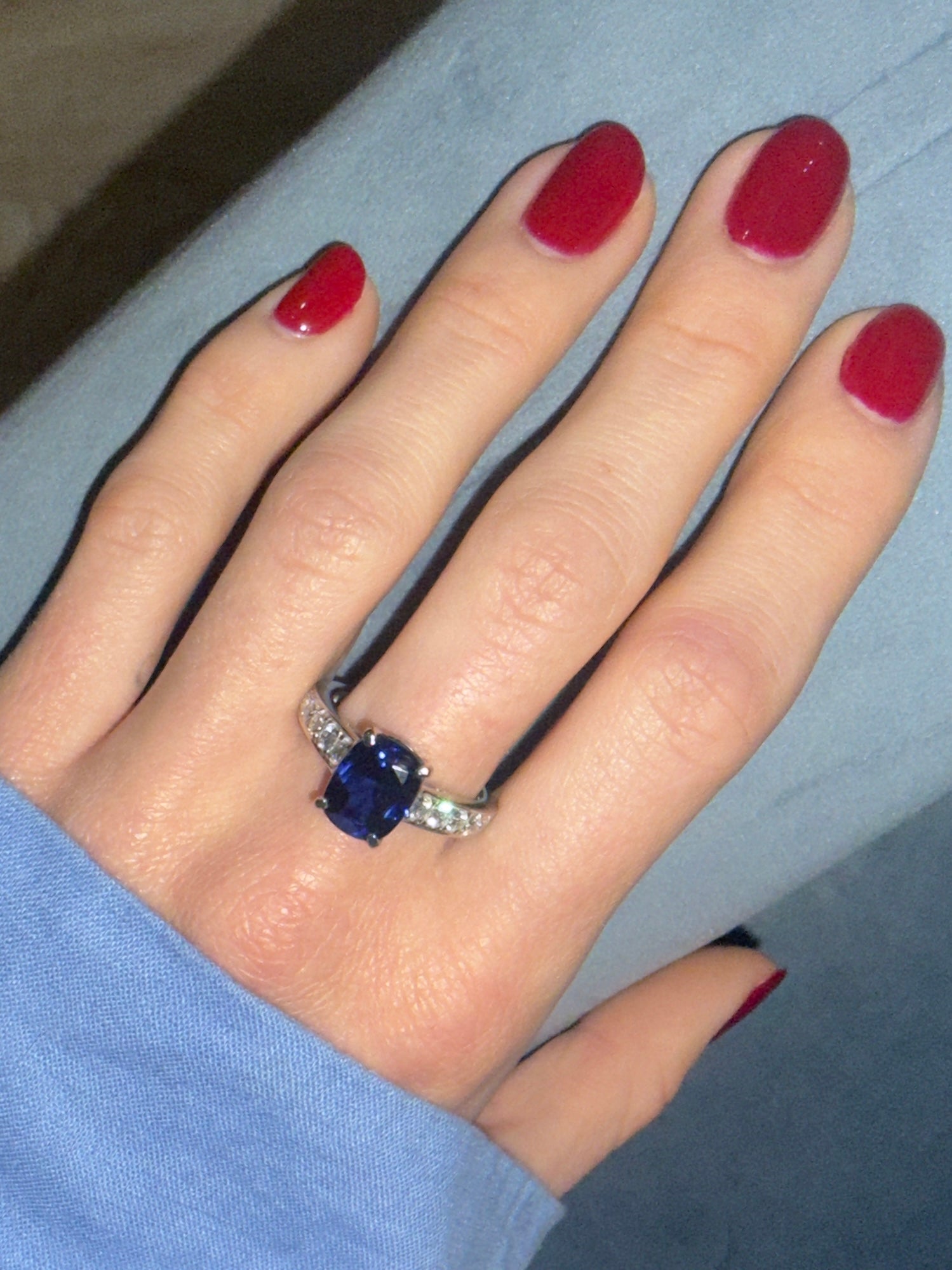 Blue Nilu 4ct blue sapphire cushion cut ring with diamonds in platinum on models hand—Waltz Diamonds