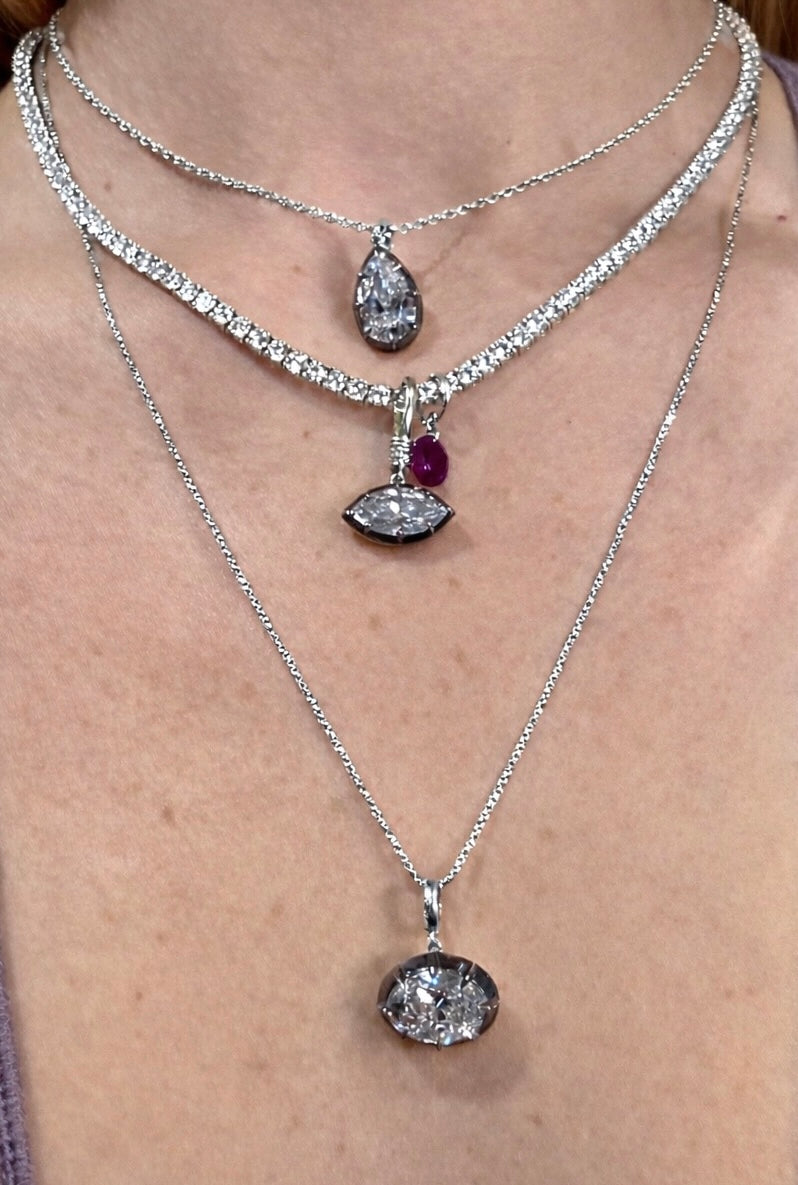 Five Kings georgian pendants in pear oval and marquise cuts stacked and styles on a model—Waltz Diamonds