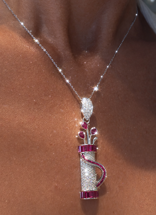 Model wearing Fore Play Pendant featuring diamonds and ruby baguettes in a golf bag charm design in white gold — Waltz Diamonds