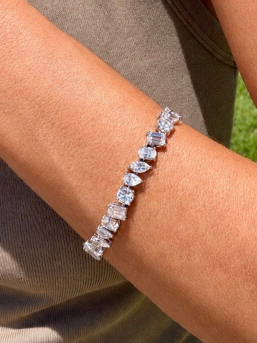 Habibi Multi-shaped tennis bracelet with pear,round,marquise,oval,and emerald cuts in white gold on wrist — Waltz Diamonds