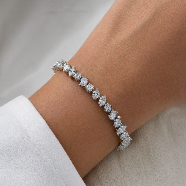 Habibi Multi-shaped tennis bracelet with pear,round,marquise,oval,and emerald cuts in white gold on wrist — Waltz Diamonds