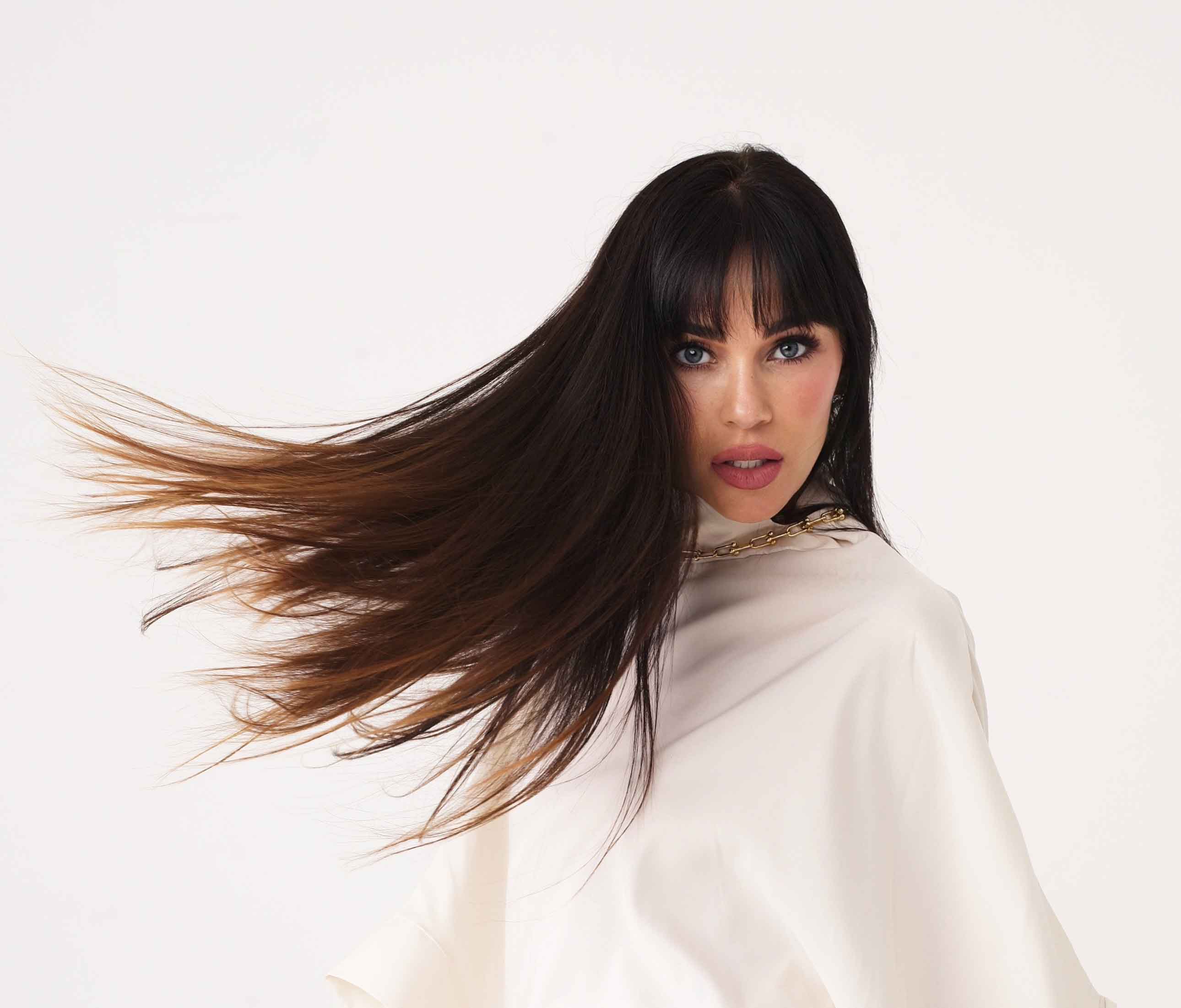 Editorial portrait of a Jasmine Waltz with flowing dark hair, styled in a white garment and wearing the Link Me Chain necklace