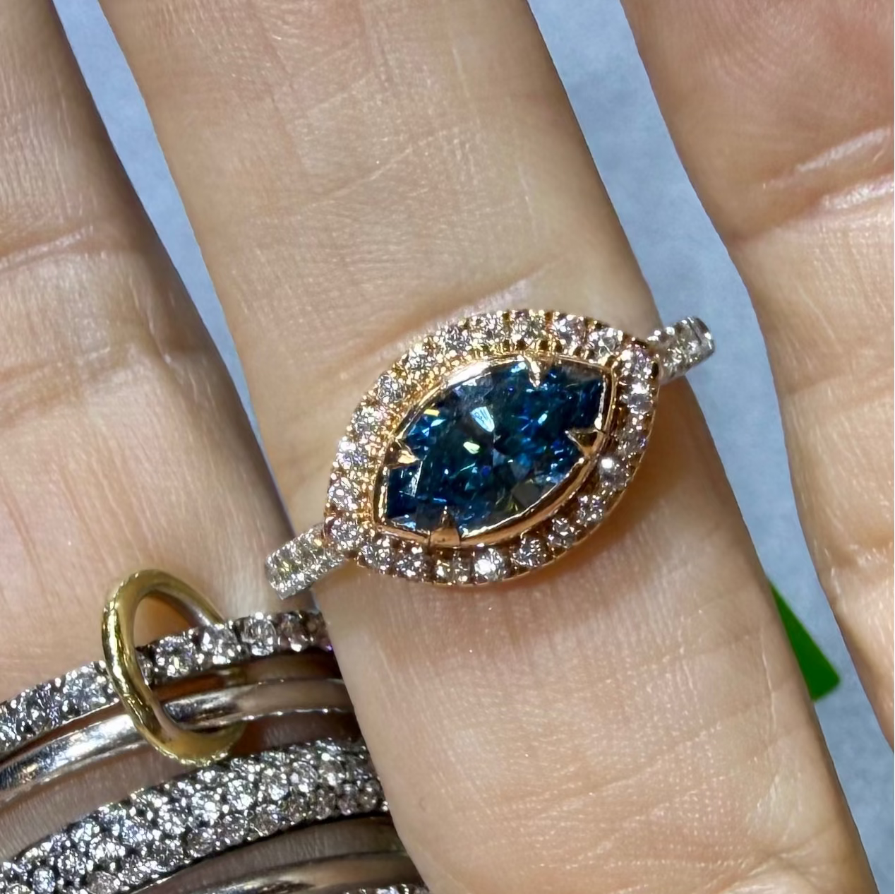 Ocean eye Blue diamond evil eye ring in yellow gold with a diamond halo  on hand— Waltz Diamonds