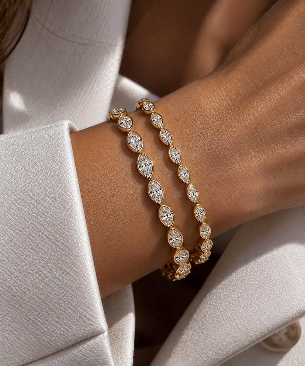 Oria marquise cut diamond east west bezel set bracelet in yellow gold two sizes shown on wrist — Waltz Diamonds