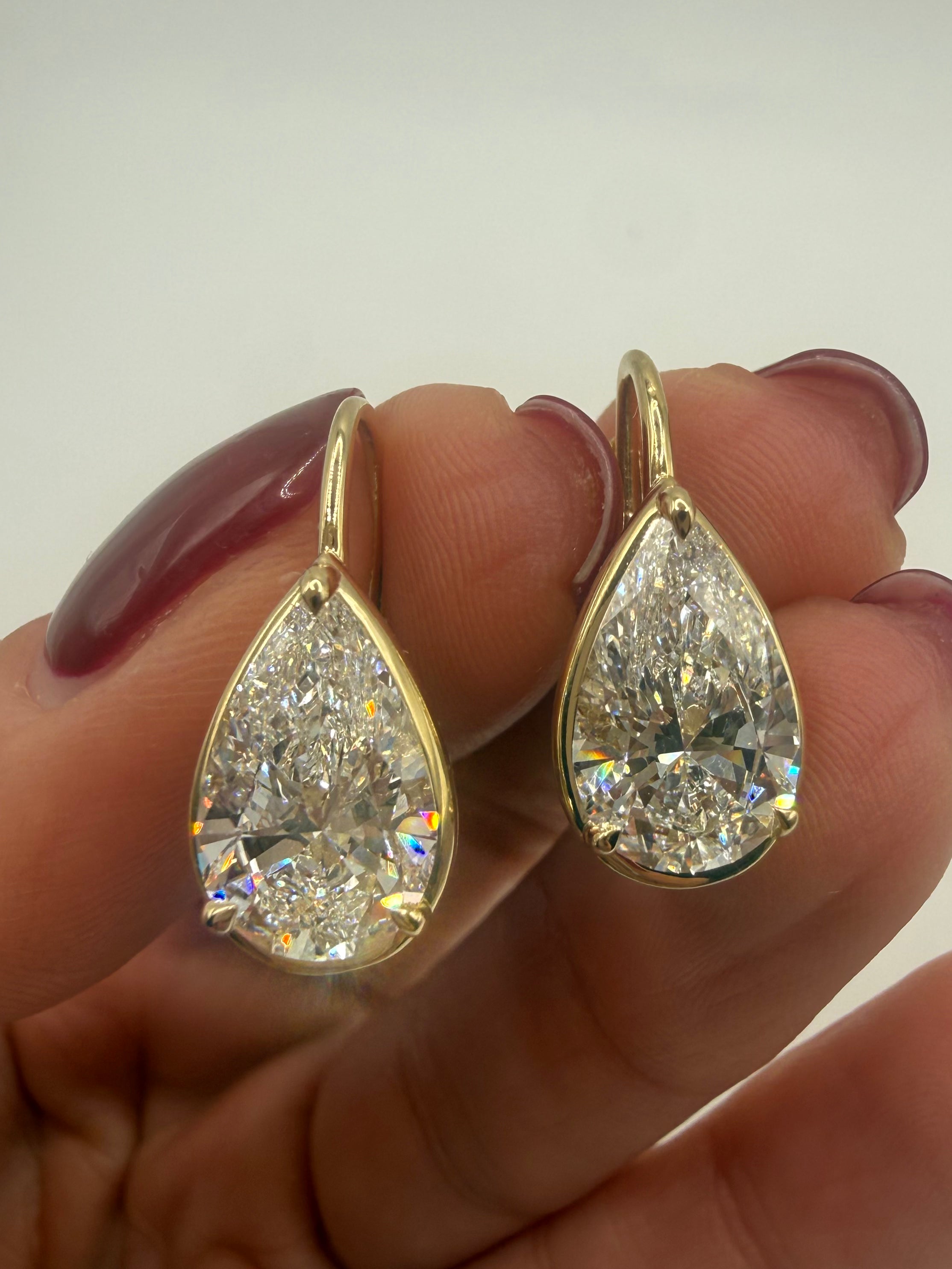 Pear Cut diamond Drop Hoops in yellow gold 6 Carat Total  held by hand — Waltz Diamonds
