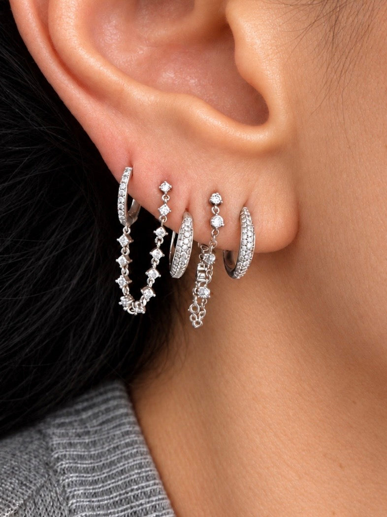 Plus one diamond chain huggie is designed for two piericngs and connects a diamond huggie with a chain of diamonds to another in white gold with earring stack on ear — Waltz Diamonds