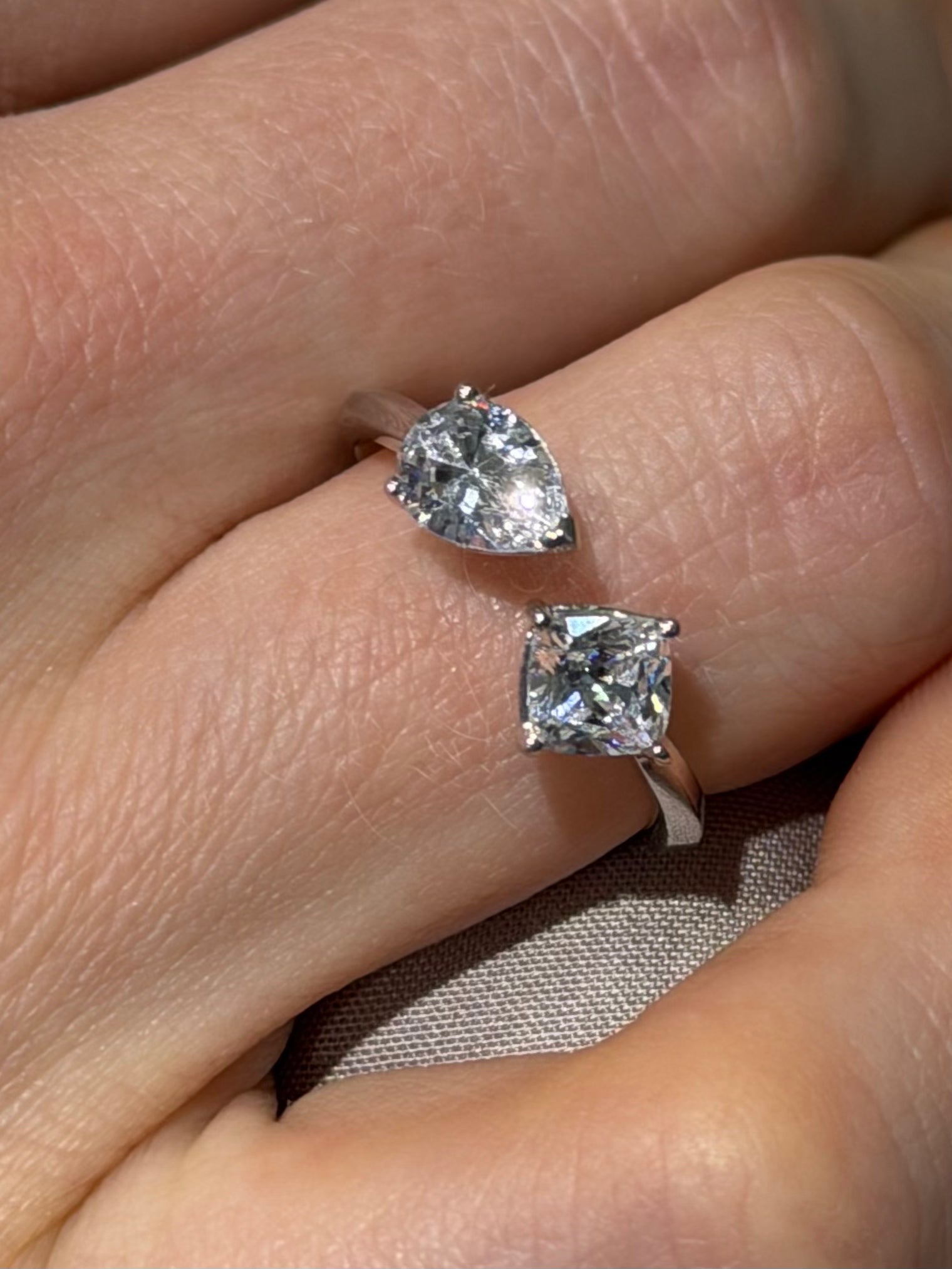 Princess pear ring featuring a pear cut and a princess cut diamond in an open asymmetrical setting white gold on hand — Waltz Diamonds
