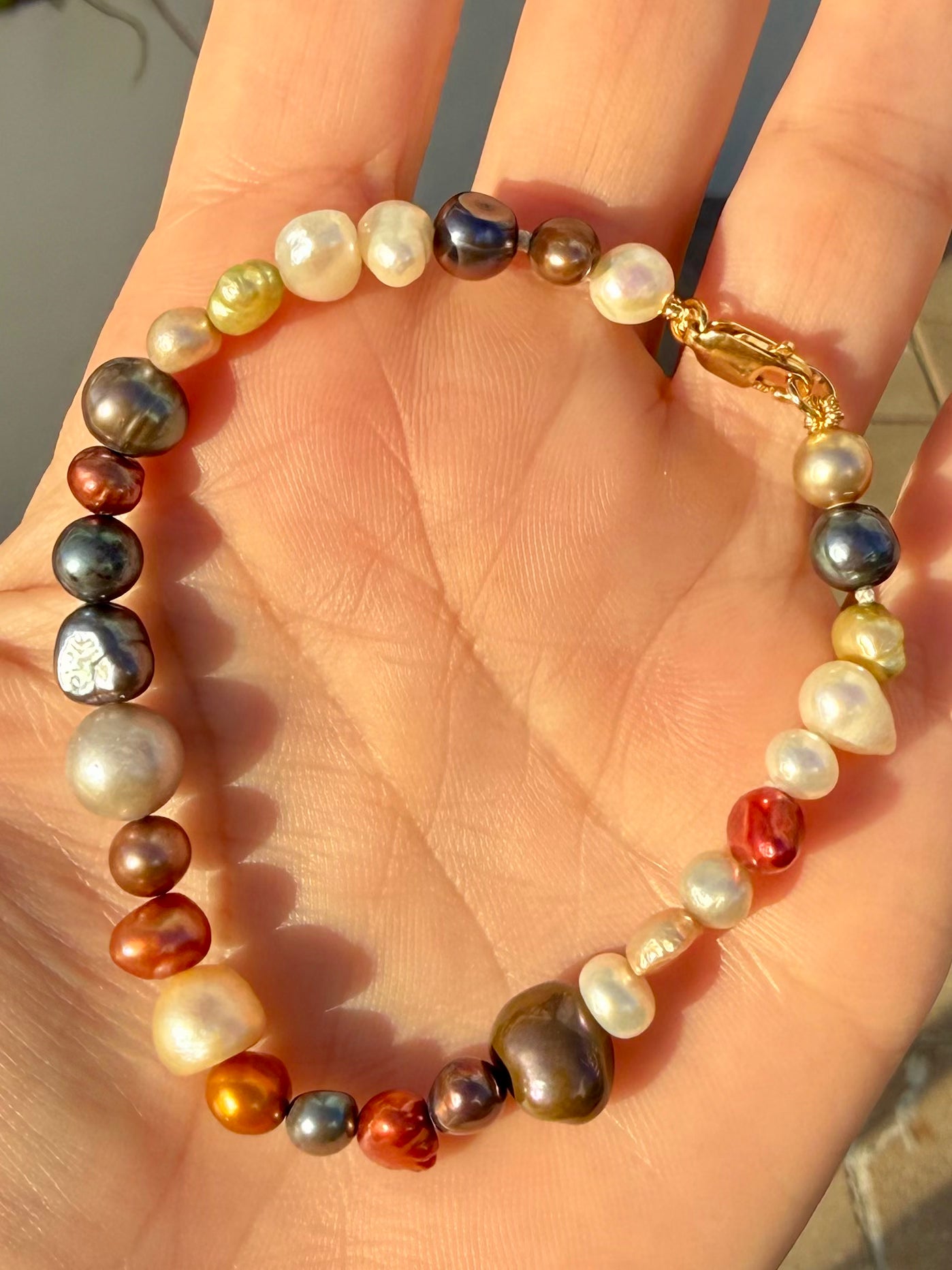 Prosperity Pearl Bracelet in multi-color held by hand—Waltz Diamonds