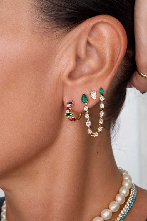 Rainbow gem huggies in yellow gold and multi-colored lab gems earrings styled on model — Waltz Diamonds
