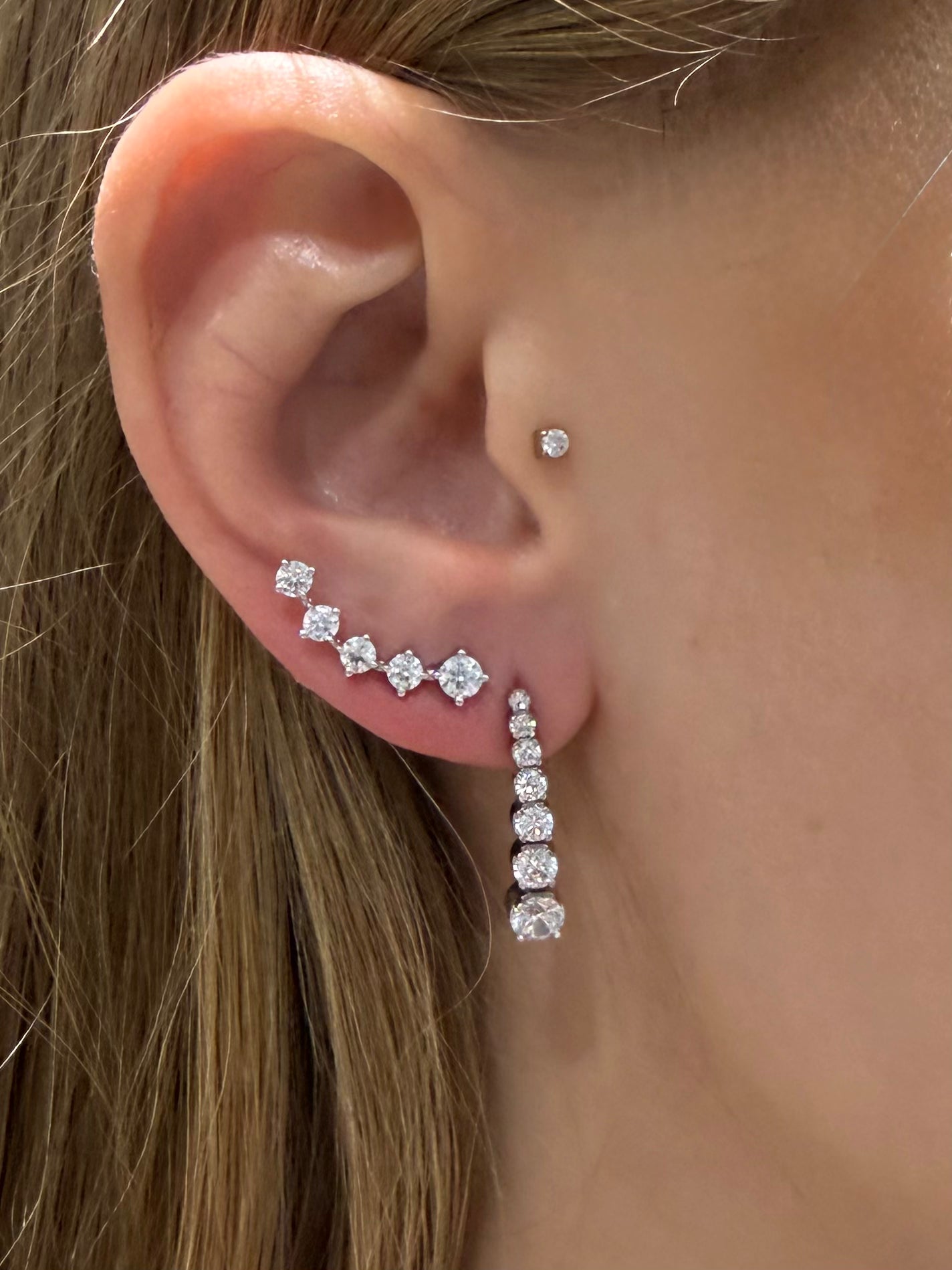 Round social climbers with five diamonds that curve perfectly up the ears in white gold styled with crescendo diamond drops— Waltz Diamonds