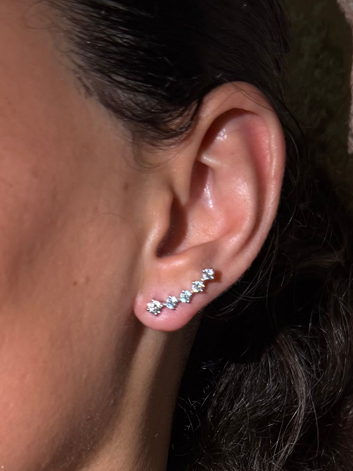 Round social climbers with five diamonds that curve perfectly up the ears in white gold on ear — Waltz Diamonds