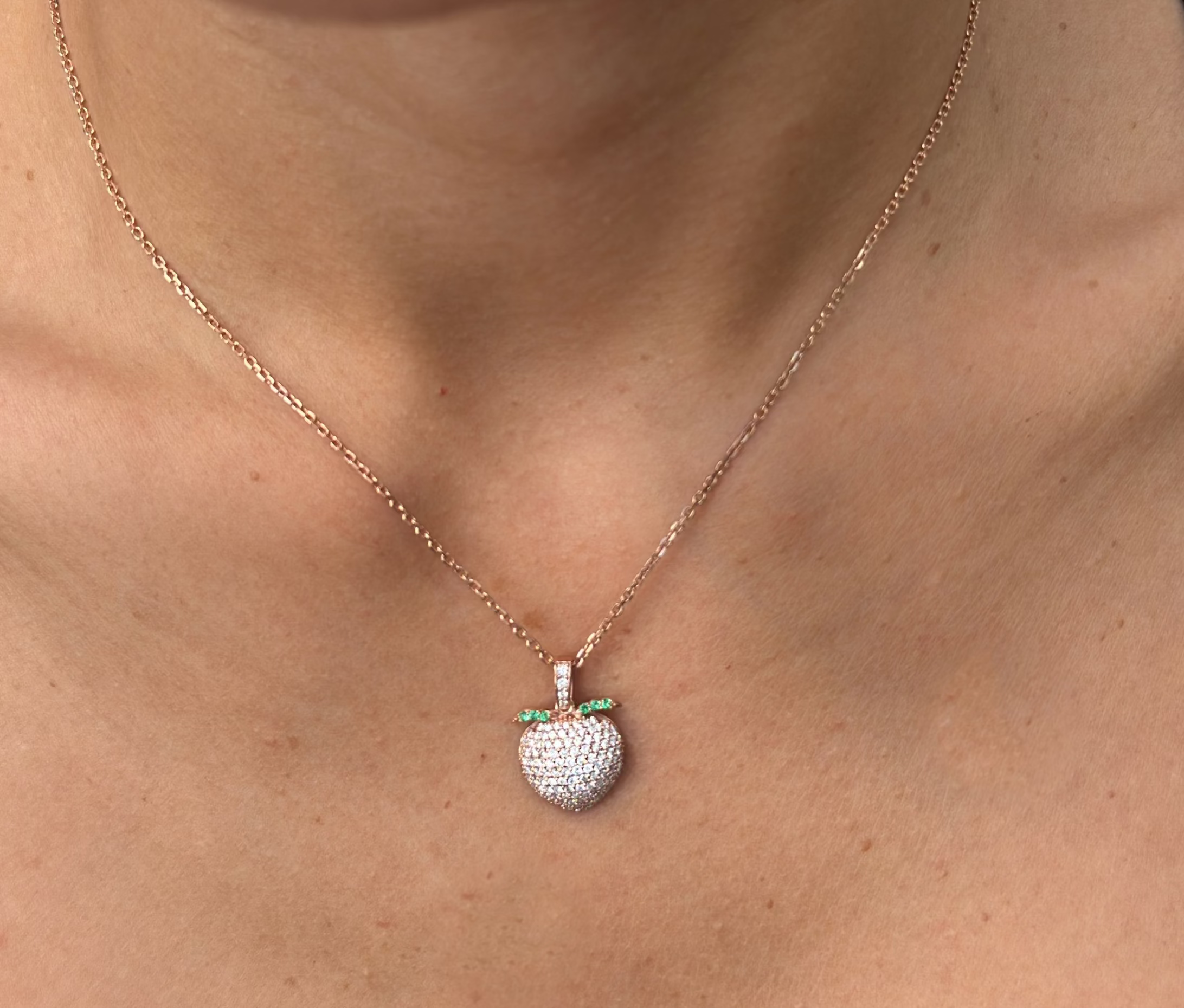 Close up of model wearing the sweet peach pendant in rose gold and sustainable diamonds.