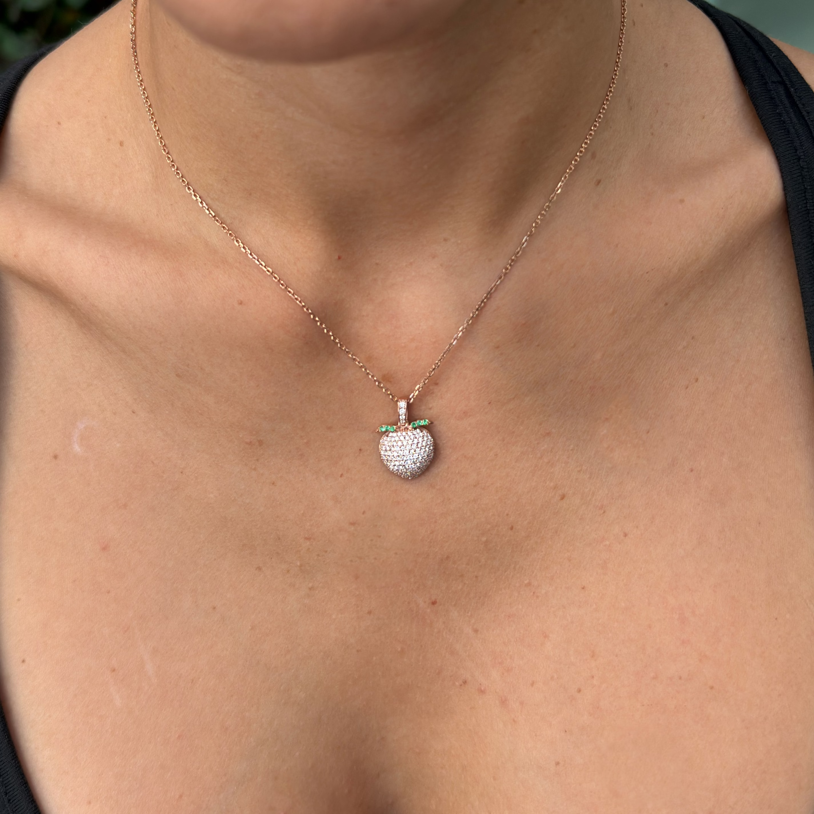 Close up of model wearing the sweet peach pendant in rose gold and sustainable diamonds.