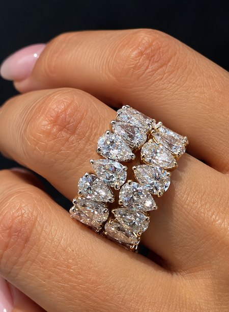 Tears of Joy rotating pear cut diamond eternity band in yellow gold on hand — Waltz Diamonds