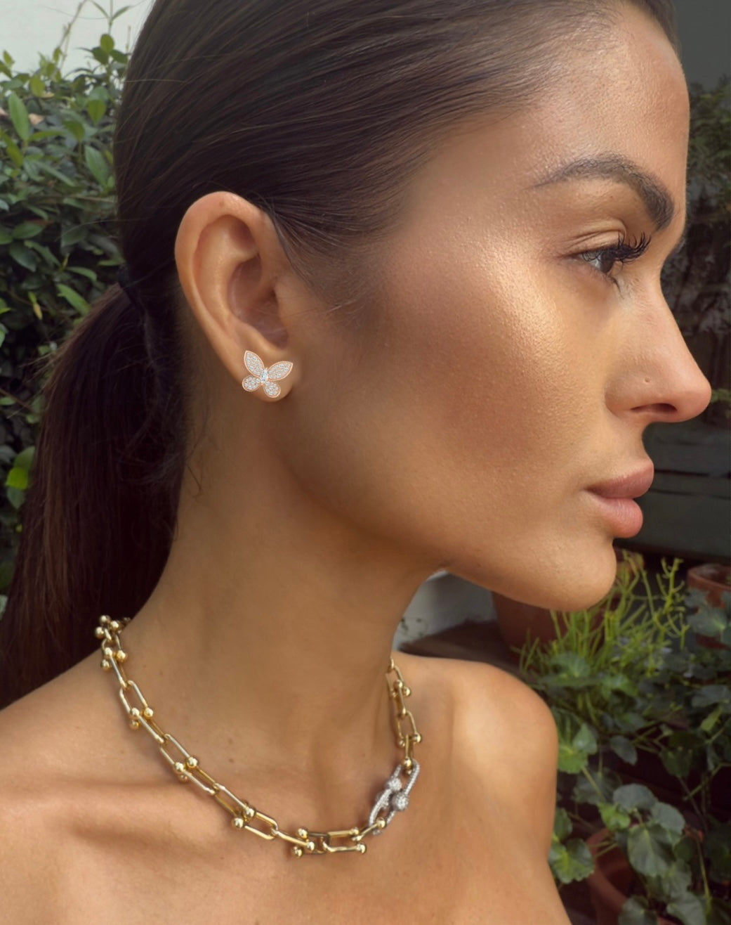 Model wearing Butterfly Kisses Pavé Stud Earrings in rose gold, showcasing whimsical butterfly design