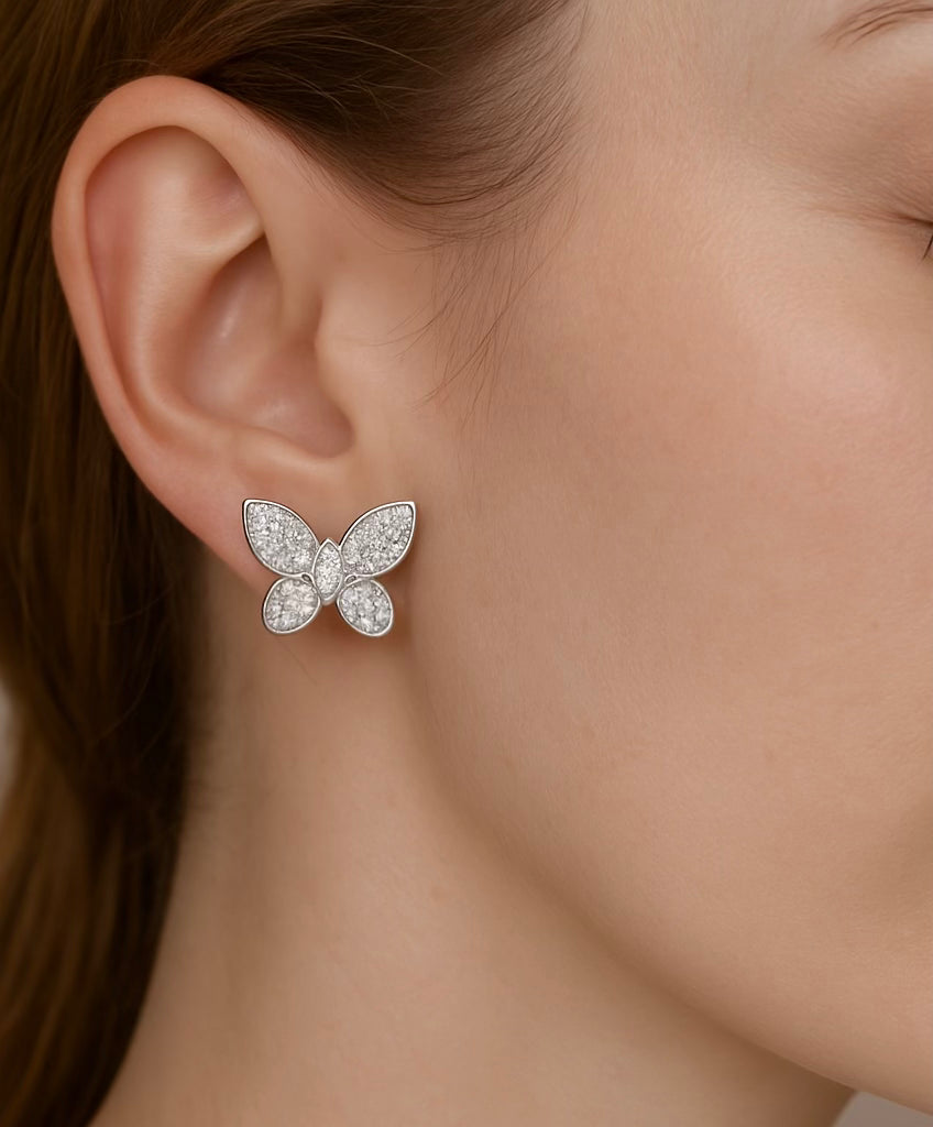 Model wearing Butterfly Kisses Pavé Stud Earrings in white gold, showcasing whimsical butterfly design