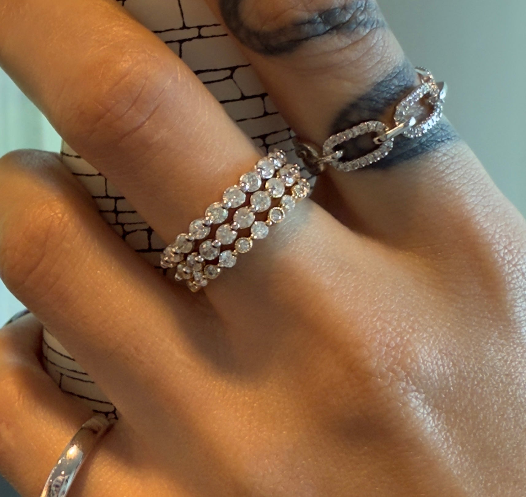 Hand model wearing Day Dreamer pavé link ring in yellow gold, showcasing its subtle shine and bold design