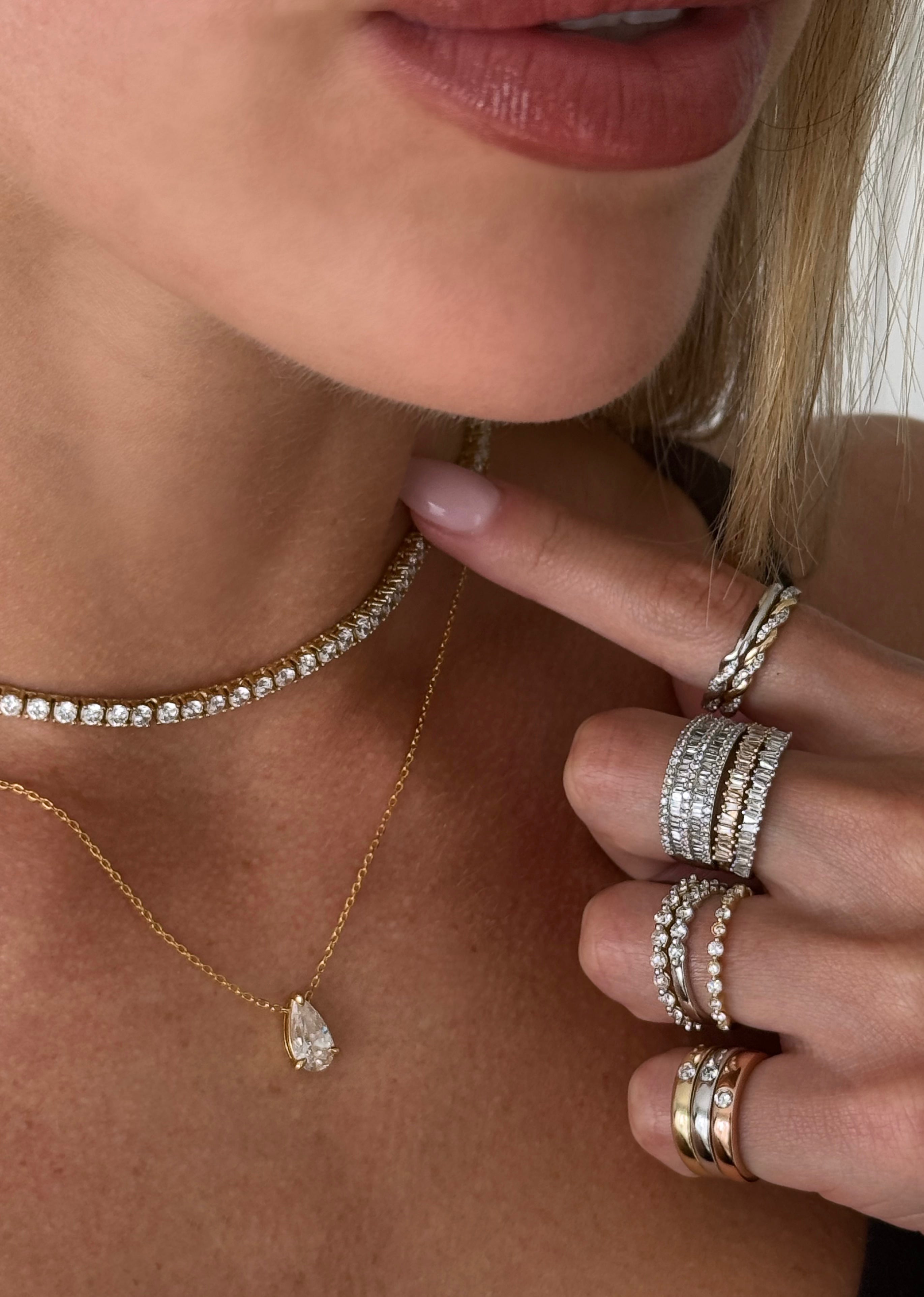 Editorial shot of a model wearing a ring and necklace stack featuring the Double Trouble Pavé x Baguette Ring.