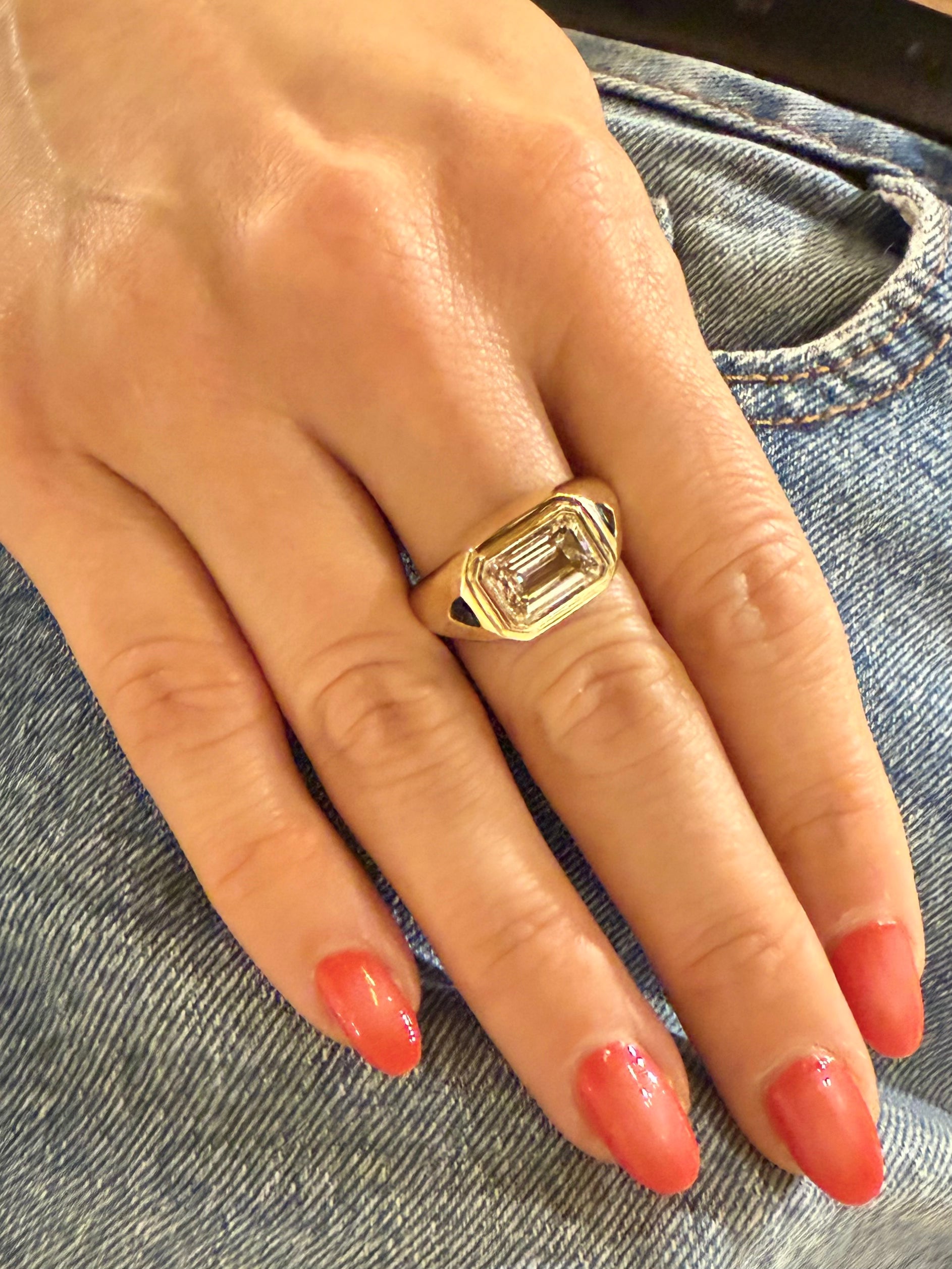 Model wearing the Femme Forte emerald-cut diamond signet ring in yellow gold with side stones