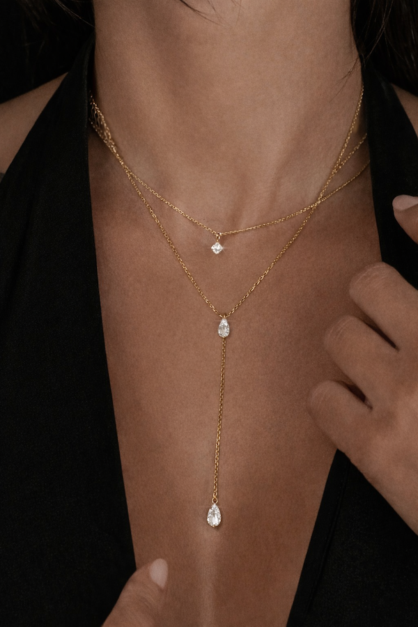 Fine line lariat necklace featuring one carat pear shape diamonds styled on a model —Waltz Diamonds