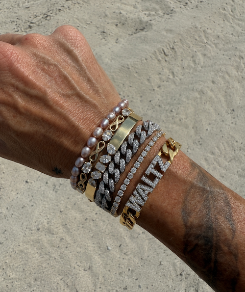 G's heirloom cuban with the name Waltz in diamonds on a gold cuban link bracelet stacked with other walts pieces