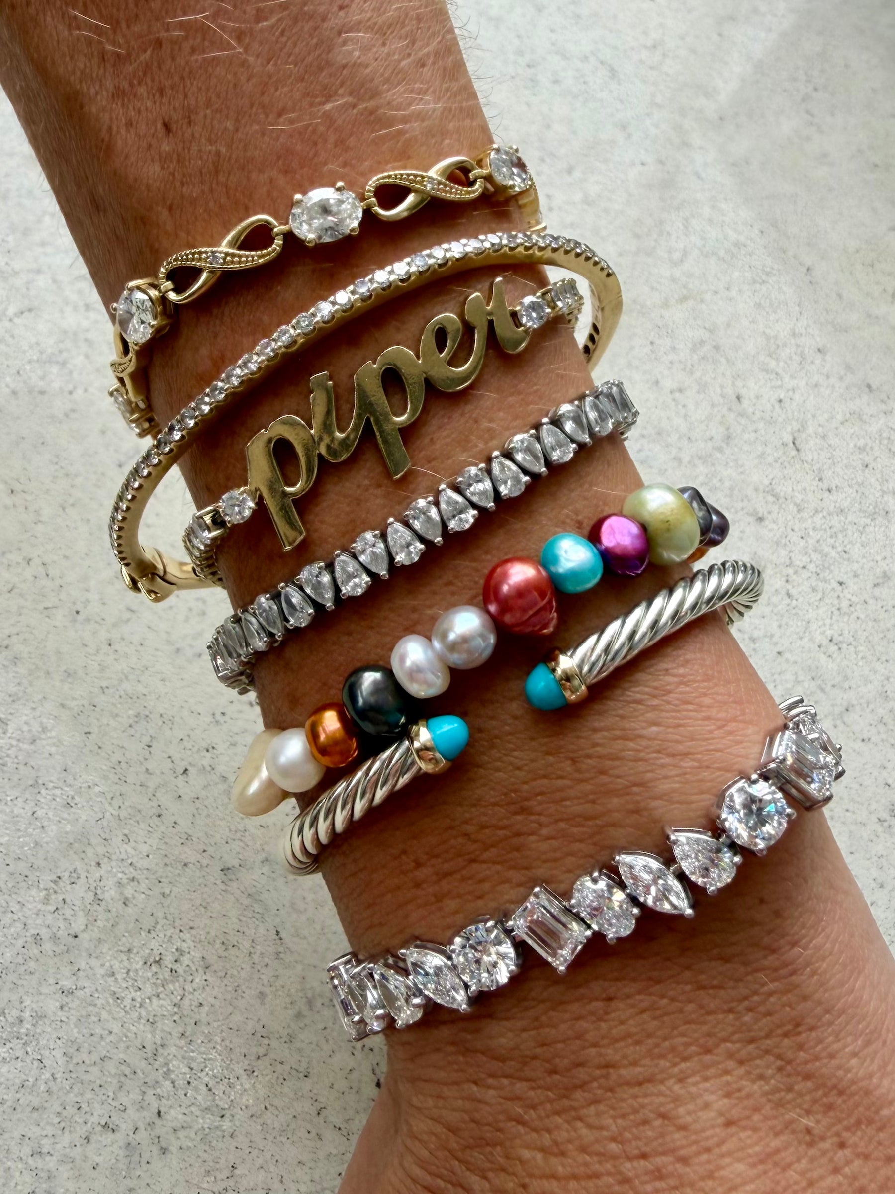 A styled wrist of all Waltz bracelets the Abundance, Habibi, Prosperity, Tears of Joy, Spoil Me, All Day Everyday, and Abundance bracelets all stacked on wrist — Waltz Diamonds