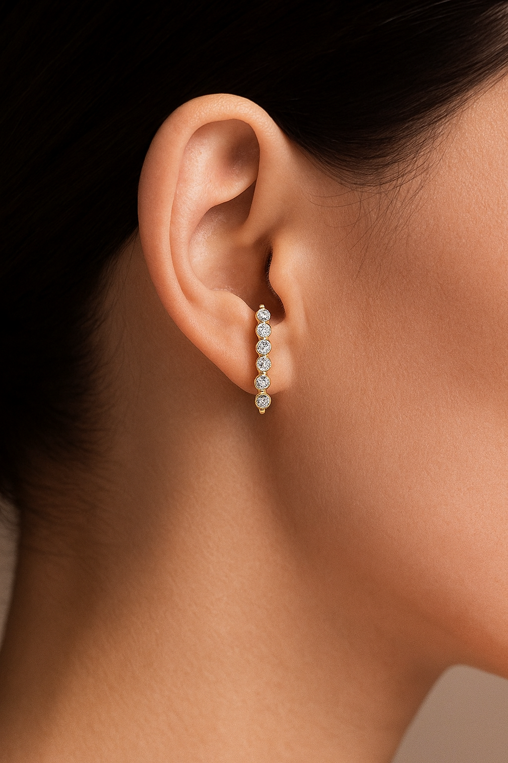 Model wearing Luna Light diamond stud earrings in yellow gold with celestial arc shape