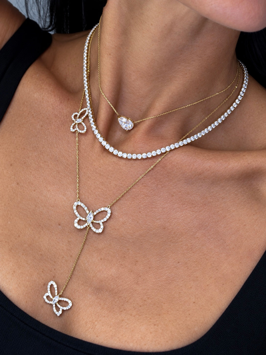 Butterfly Effect Lariat necklace with 3 suspended butterflies with marquise center stones in yellow gold, center of attention necklace and the sideways pear choker styled on model — Waltz Diamonds