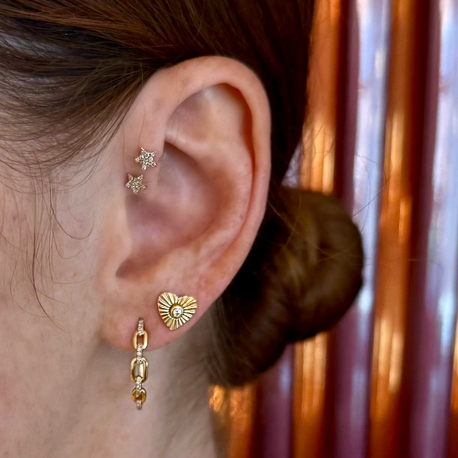 Model wearing Twinkle star studs in curated ear stack, editorial image close-up.